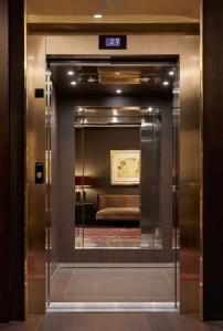 戈赖斯Hotel Castillo de Gorraiz&Spa的电梯开往带镜子的酒店客房