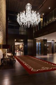 戈赖斯Hotel Castillo de Gorraiz&Spa的一个带吊灯和红色地毯的大型大堂