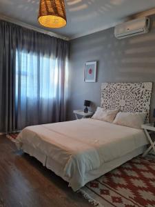 德班African Cycad Holiday Home的一间卧室设有一张大床和一个窗户。