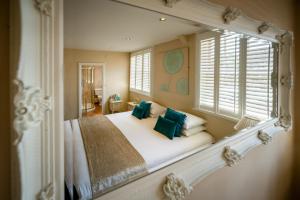 亨利因阿登The White Swan Hotel Bar & Restaurant的一间卧室配有一张带绿色枕头的大床