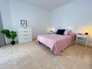 洛斯克里斯蒂亚诺斯埃迪菲西奥唐迭戈公寓的一间卧室配有床、梳妆台和植物
