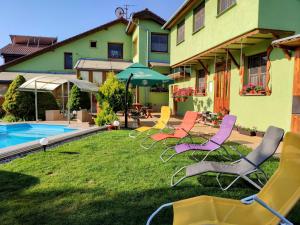 斯米扎尼Villa Real Paradise的坐在房子旁边的草上一组椅子