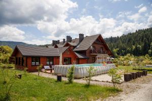 齐斯纳Solny - Resort w Bieszczadach的一座木屋,前面设有一个游泳池