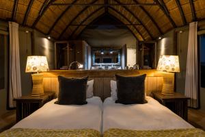KhorixasMowani Mountain Camp的一间卧室配有两张床和两盏灯。