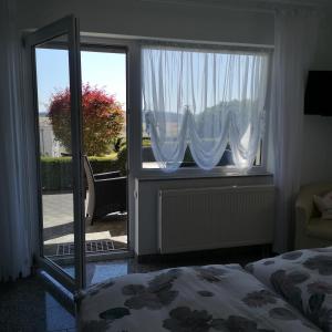 德廷根Haus Marvin的一间卧室设有一张床和一个滑动玻璃门