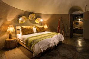 TwyfelfonteinCamp Kipwe的卧室配有一张床,墙上有两面镜子