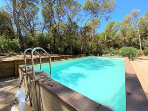 埃斯卡洛Can Valonsadero, Villa con Piscina的一个带椅子的游泳池,靠近围栏