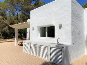 埃斯卡洛Can Valonsadero, Villa con Piscina的甲板上设有水槽的白色房子