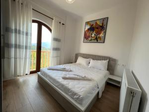 BurreliBujtina Celiku的白色卧室设有一张带窗户的床