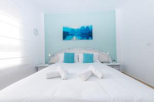 卡亚俄萨尔瓦赫La sonada bright penthouse with views的卧室配有白色床和蓝色的墙壁