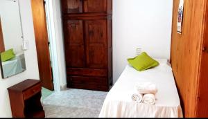 坦季Lo de Liliana的一间卧室配有一张带绿色枕头和毛巾的床