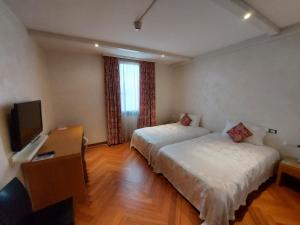 San Giorgio in Bosco波斯塔77酒店的酒店客房设有两张床和电视。