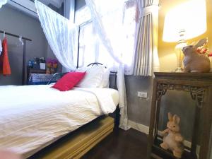 曼谷常忆住宿加早餐旅馆 的一间卧室配有一张床,窗户配有一个塞满兔子的窗户