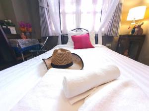 曼谷常忆住宿加早餐旅馆 的一间卧室,配有一张床,上面有帽子