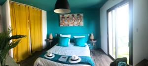 滨海萨纳里Villa Marina的一间卧室拥有蓝色的墙壁,配有一张带蓝色枕头的床。