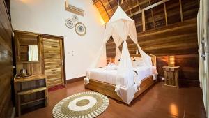 珀尼达岛Griyatama Bungalow的一间卧室配有一张带蚊帐的床
