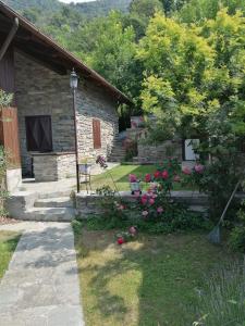 San GiulianoChalet di Montagna的一座石头房子,带鲜花的院子