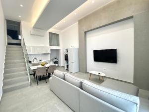 迈索尼亚历克斯酒店 的客厅配有沙发和墙上的电视