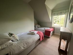 LoanheadQuaint self contained cottage near Edinburgh.的一间卧室设有两张床和窗户。