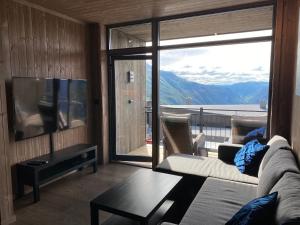 尤坎New apartment, Gausta in Rjukan. Ski in/ ski out的带沙发和大窗户的客厅
