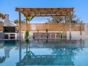 MouzákionSonel Luxury Villa, a Family Retreat, By ThinkVilla的一个带木制凉棚和庭院的游泳池