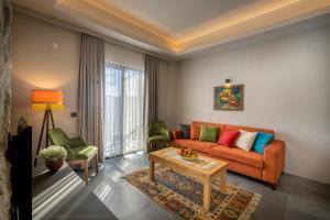EmecikDADYA BORA HOTEL的客厅配有橙色沙发和两把绿色椅子