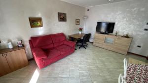 龙基德伊莱焦纳里Rose e Frutta ristrutturato con parcheggio的客厅配有红色沙发和电视