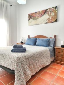 贝瑙卡斯El Jándalo的卧室配有一张床,墙上挂有绘画作品