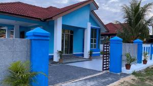 Kampong TamanSeri Idaman Guest House (Pasir Mas)的蓝色房子,有红色屋顶