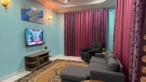 Kampong TamanSeri Idaman Guest House (Pasir Mas)的带沙发和电视的客厅