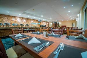 艾因苏赫纳Blumar El Dome Hotel的用餐室配有带餐巾和银器的木桌