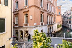 威尼斯卡萨皮特罗卡酒店的妇女在大楼前的阳台上行走