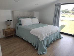 NoisPOLAS BEACH LOFT的一间卧室配有一张带绿毯的床和窗户。