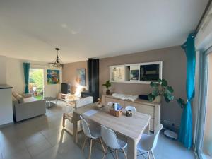 罗克布伦河畔阿尔让Maison avec piscine, climatisée, proche plage的厨房以及带桌椅的起居室。
