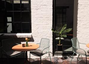马斯特里赫特Cousins Boutique Hotel的庭院设有两把桌子和椅子,种植了植物