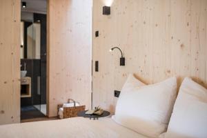 罗萨Stadl Chalet oberhalb Brixen的卧室配有带白色枕头和桌子的床