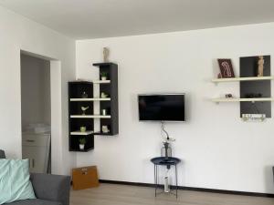 皮亚特拉-尼亚姆茨Tourist Apartment 1的一间客厅,在白色的墙上配有电视