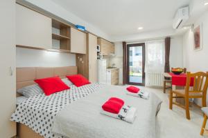波雷奇Alex Deluxe Apartments on Beach的一间卧室配有一张大床和红色枕头