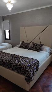 埃塞萨Like at Home Ezeiza的一间卧室配有一张大床和大床头板
