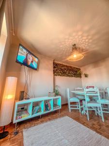 卡米尼亚Casas Sebastião - Tourist House的客厅配有桌子和墙上的电视