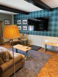 埃斯克代尔埃尔顿厅酒店的带沙发、桌子和电视的客厅