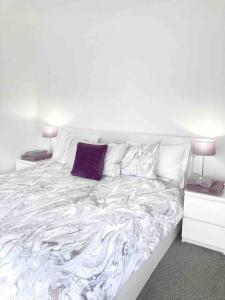 庞蒂浦Caithness Holiday Home的白色的床和紫色枕头