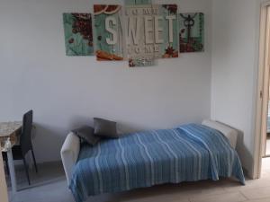 奇维塔韦基亚Home Sweet Home的一间卧室配有一张带蓝色毯子和一张桌子的床。
