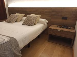 Cervera del Río AlhamaHotel Cervaria的一间卧室配有两张床,一个床头柜配有一张四柱床