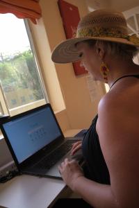 圣佩德罗BELIZE TROPICAL DREAM VILLAS的坐在笔记本电脑上的戴帽子的女人