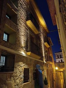Cervera del Río AlhamaHotel Cervaria的一座古老的石头建筑,晚上设有阳台