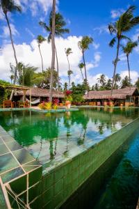 圣米格尔-杜戈斯托苏Bangalô Kauli Seadi Eco-Resort的棕榈树度假村的游泳池
