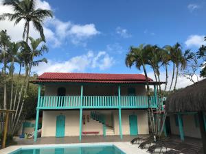 伊利亚贝拉Pousada Maria Felipa Ilhabela的一座带游泳池和棕榈树的房子