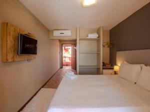 莫罗圣保罗拉特瑞斯酒店的卧室配有一张大床,墙上配有电视
