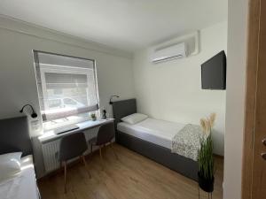 佐洛埃格塞格D 20 Apartmanház Zalaegerszeg Dózsa György utca 20的小房间设有床、书桌和窗户